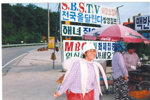 하루종일 뙤약볕 길거리에 서서 오징어 춤을 추며 손님들을 맞는 그녀가 잠시 휴식을 취하러 가게 안으로 들어가고 있다. 